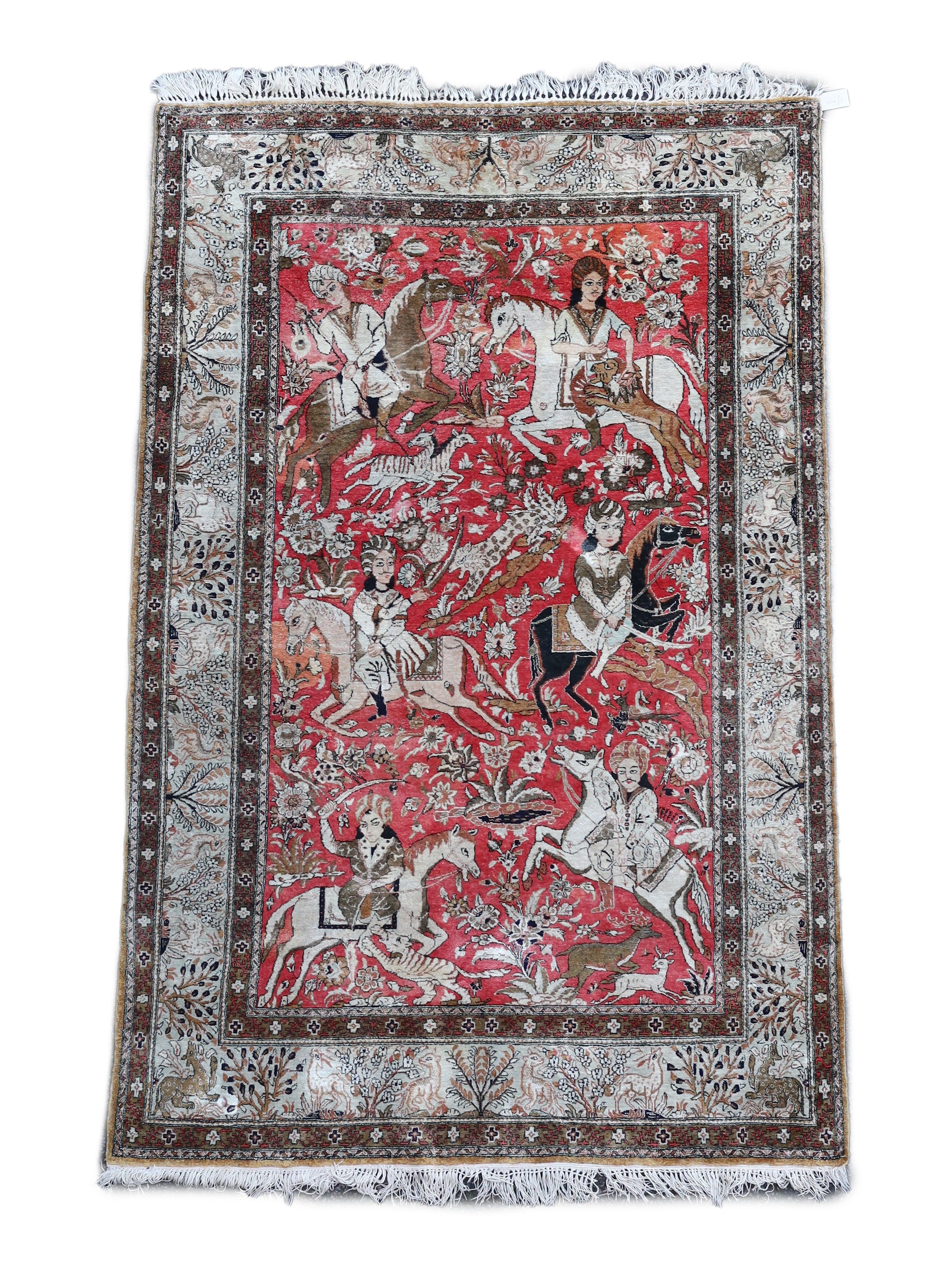 An early 20th century Tabriz pictorial red ground rug, woven with hunters on horseback, 208 x 135cm.